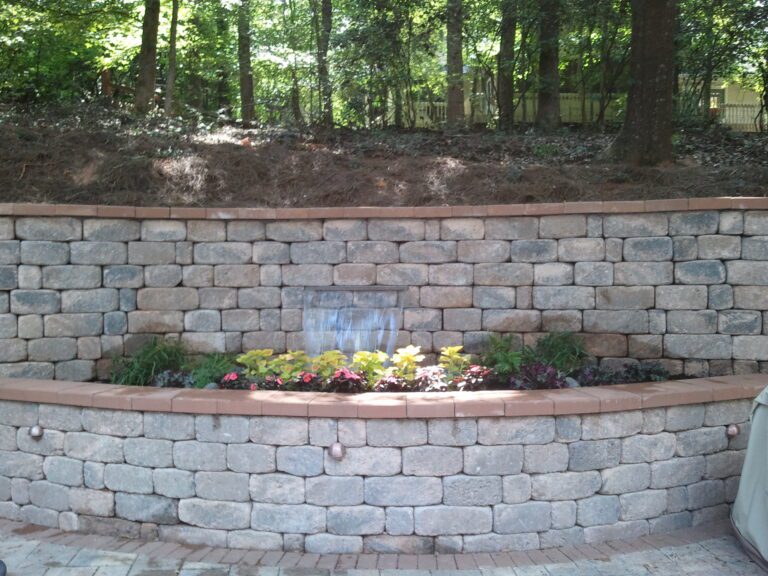 paver patio with retaining wall and water fall designed and installed by The Brickyard in Lakeland Central Florida