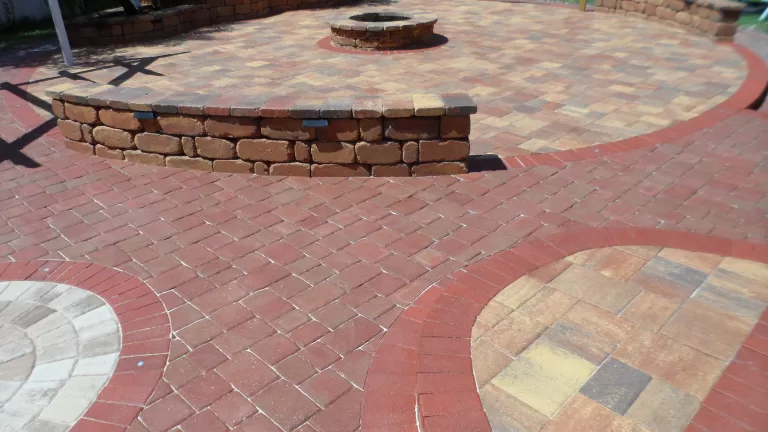 varying colors of stone pavers installed on a patio with wall and firepit