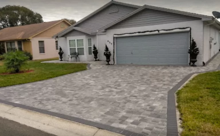 grey paver driveway in front of single story home
