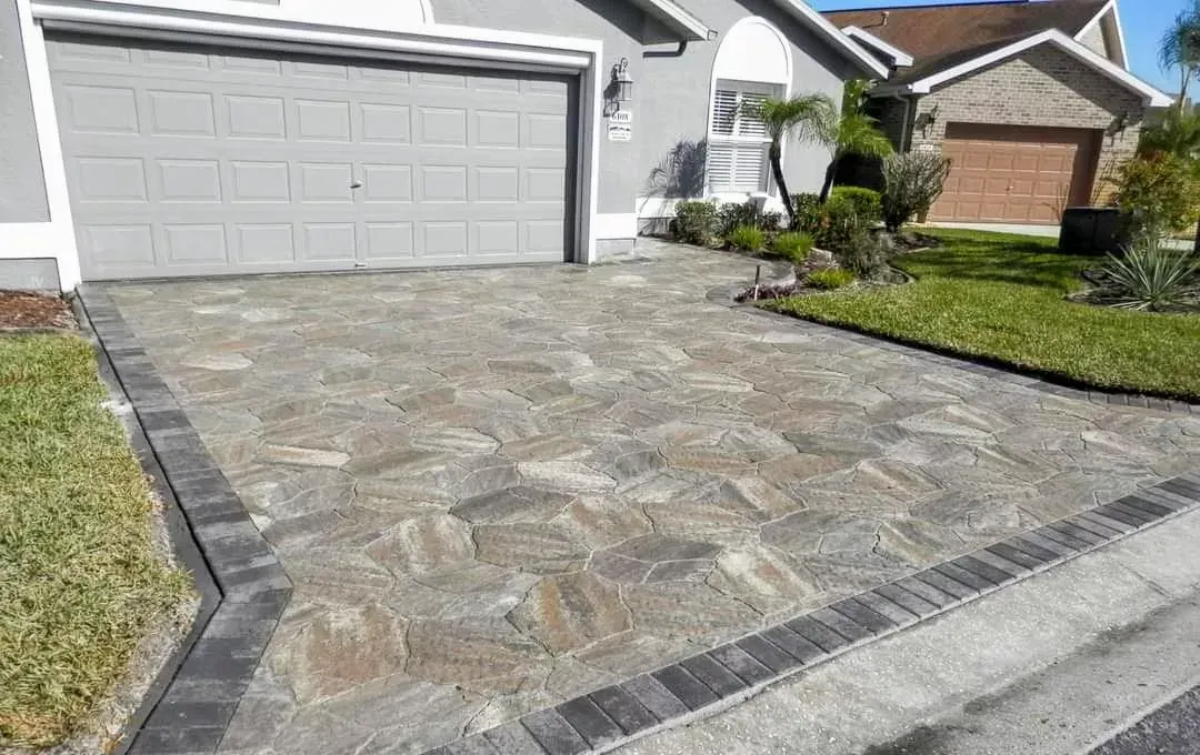 A driveway in front of a house with a garage door.