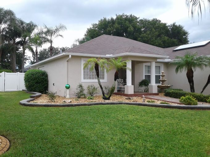 A house with a lush green lawn in front of it